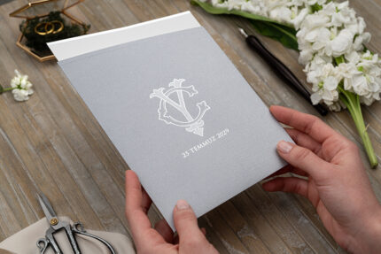 el ile tutulan gri zarflı sade düğün davetiye örneği